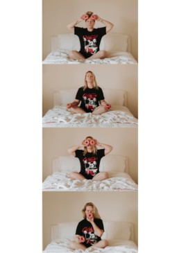 femme blonde sur un lit qui joue avec des donuts rose