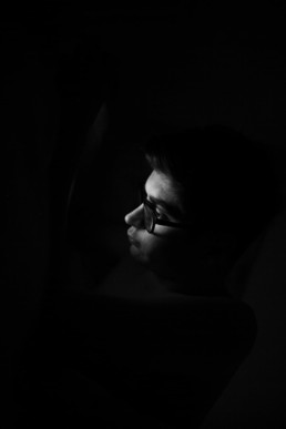 photo d'un adolescent qui regarde son téléphone la nuit. Enfant avec lunettes de vue, photo en noir et blanc