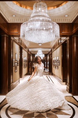 mariée qui fait tourner sa robe dans un hôtel de luxe avec lustres en cristal de baccarat