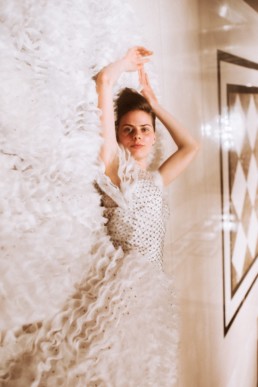 mariée allongée par terre sur sa robe de mariage dans les couloirs de l'hôtel. robe en mousseline et diamant