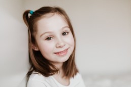portrait d'une petite fille avec une couette, rousse aux yeux verts