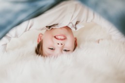 portrait d'un enfant tête en bas jambes ouverte sur le lit à Jacou