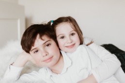 portrait d'un grand frère et de sa petite soeur qui se tiennent dans les bras à Lavérune