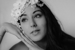 portrait en noir et blanc d'une femme brune appuyé sur ses mains sur le coté
