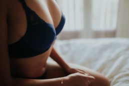 gros plan sur la poitrine d'une femme, soutient gorge bleu, mains croisés