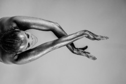 femme les bras tendus en l'air et croisés, paillette sur le corps