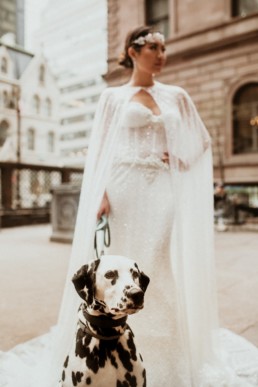 une mariée qui tiens en laisse son chien un dalmatien a new york devant le lotte palace new york hôtel