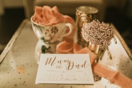 faire-part de mariage à new York blanc et calligraphie doré. Ruban de mariage, et table en verre fumé