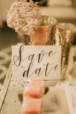 carton d'invitation de mariage save the date avec calligraphie en or. ruban de mariage rose oranger