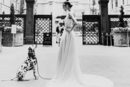 une future mariée en robe blanche longue et son chien un dalmatien avant la ceremonie de mariage a new york