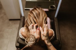 coiffeuse aux mains tatoués, formes les cheveux d'une blonde. Salon de coiffure diane laure à saint jean de vedas