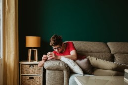 photo d'un adolescent sur le canapé qui joue avec son téléphone