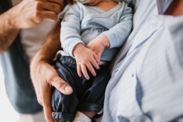 photo main d'un nouveau né dans les bras de son grand pere. trois générations d'hommes à nimes