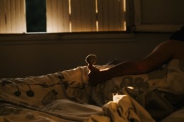 photo d'un doudou dans les mains d'un enfant dans son lit l'été