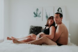 couple assis sur le lit dans la chambre, avec femme enceinte grossesse a montpellier