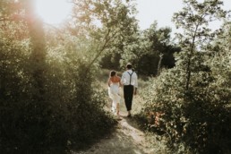 mariés dans une prairie pour un mariage en automne. Robe bustier avec traine en mousseline