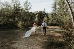 mariés qui marche dans une prairie en provence. plus belle photo de mariage