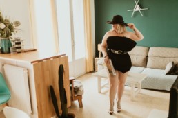 femme blonde pillow challenge dans le salon en france. oreiller noir et chapeau