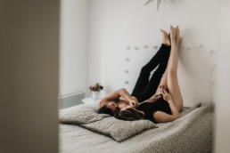 un couple les pieds en l'air contre le mur, joue dans la chambre sur le lit à Sète