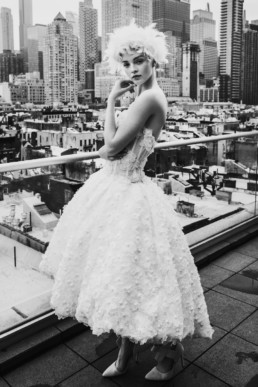une jeune mariée sur un rooftop de new york. Robe de mariée style marilyne monroe, couronne de plume dans les cheveux