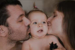 bisous des parents sur les joues de bébé fille, en peau à peau à la grande motte