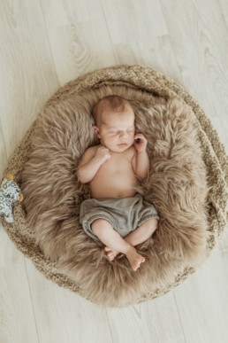 un bébé qui dort dans son couffin en peau de lapin et un bloomer vert, à la maison au Grau-du-Roi en Lagueddoc-Roussillon