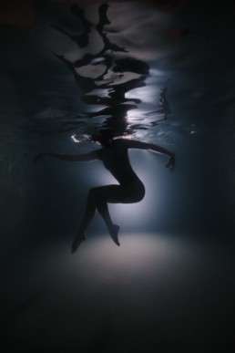 femme qui danse dans une piscine en contre jour de la lumière à Montpellier