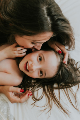 photo d'une maman qui fait un bisous sur la joue a sa fille dans la chambre à Eyguieres